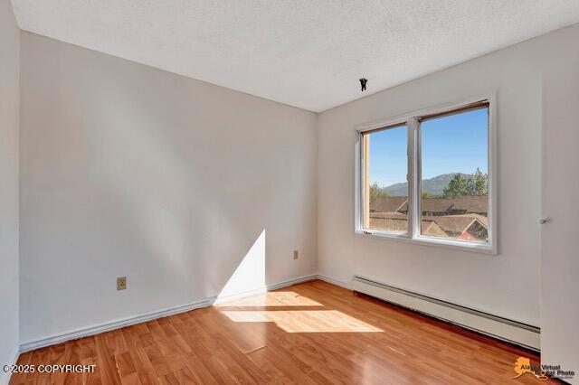 7750 Boundary Ave # A3, Anchorage, AK 99504 - unfurnished room with baseboard heating and wood finished floors