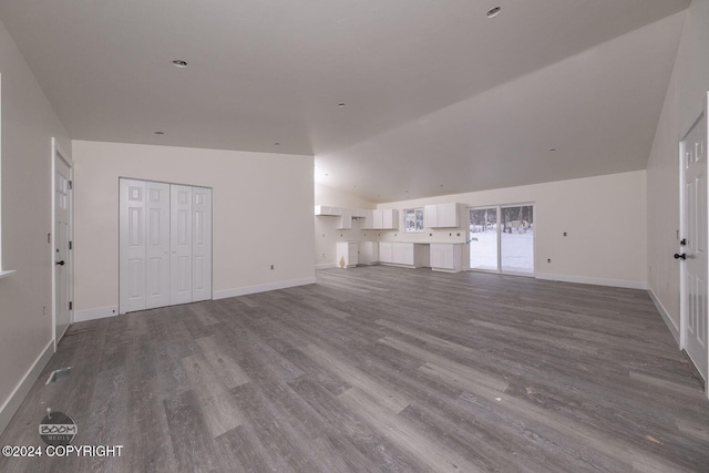 unfurnished living room featuring hardwood / wood-style flooring and vaulted ceiling