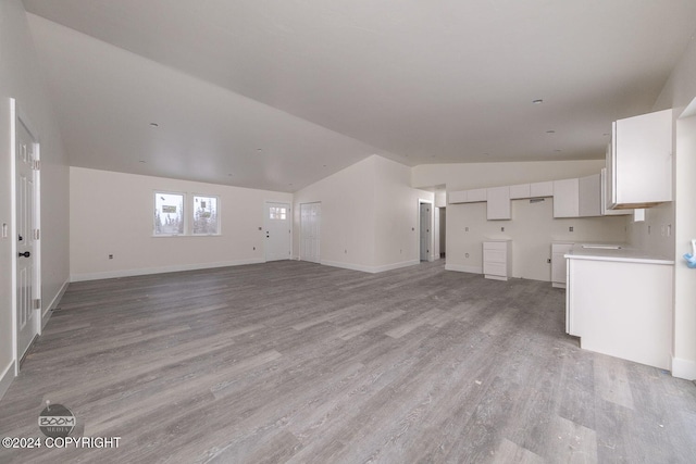 unfurnished living room with lofted ceiling and light hardwood / wood-style floors