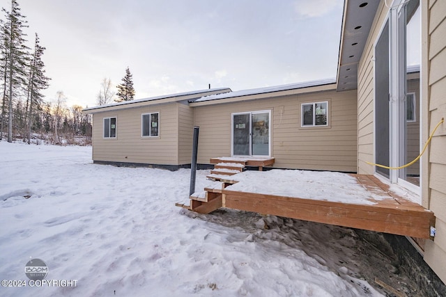 view of snow covered rear of property