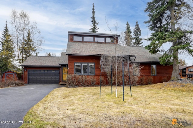 view of front of home with a shingled roof, an attached garage, driveway, and a front lawn