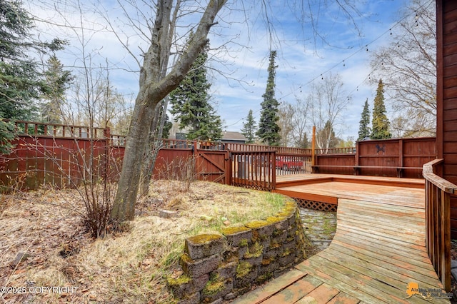 wooden terrace featuring a fenced backyard