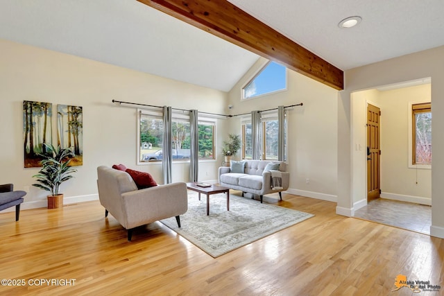 living area with light wood-style floors, baseboards, and lofted ceiling with beams