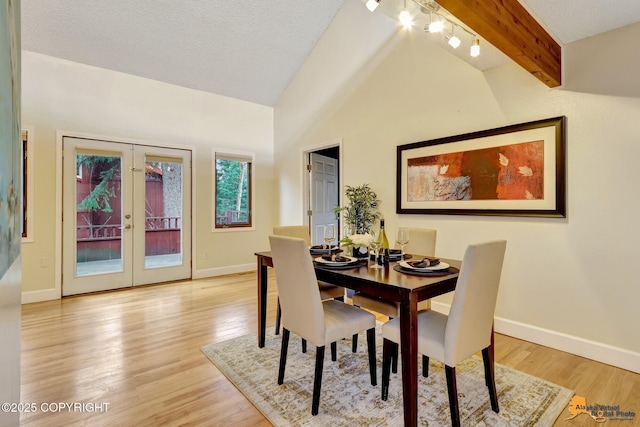 dining space featuring vaulted ceiling with beams, baseboards, french doors, and light wood-type flooring