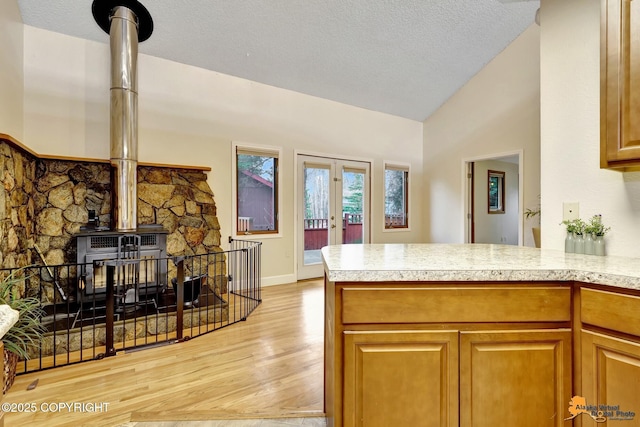 kitchen with light countertops, vaulted ceiling, french doors, and light wood-type flooring