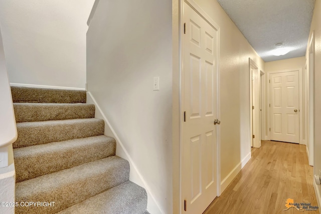stairs with baseboards and wood finished floors