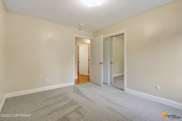 unfurnished bedroom featuring a closet, baseboards, carpet flooring, and a textured ceiling