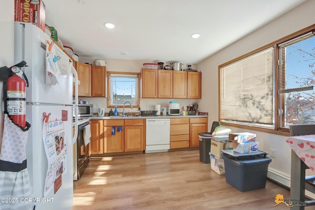 kitchen featuring white appliances, light wood finished floors, light countertops, a sink, and recessed lighting