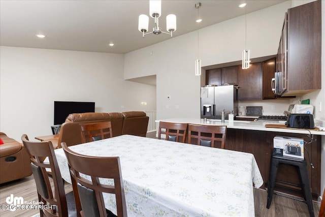 dining room featuring an inviting chandelier, sink, and light hardwood / wood-style flooring