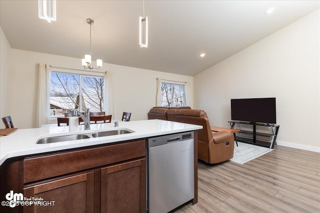 kitchen with lofted ceiling, sink, hanging light fixtures, light wood-type flooring, and dishwasher