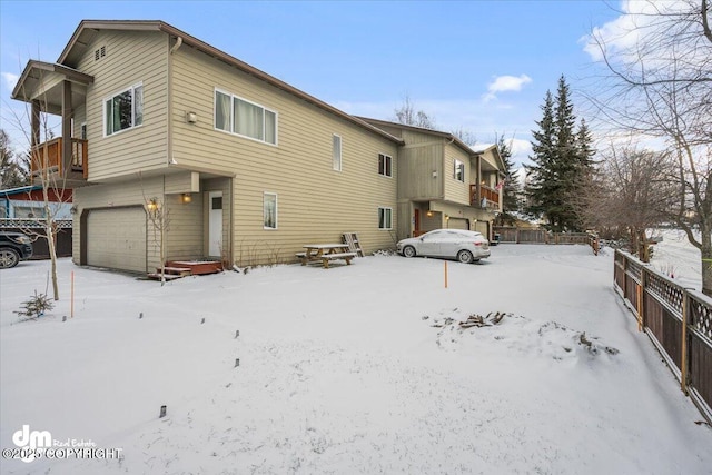 snow covered property with a garage