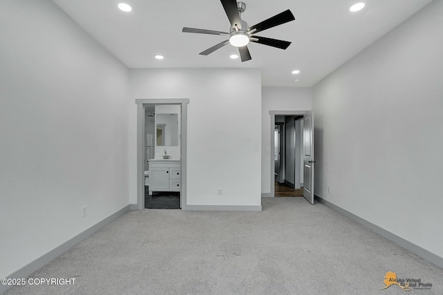 unfurnished bedroom featuring light carpet and connected bathroom