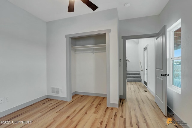 unfurnished bedroom with ceiling fan, a closet, and light hardwood / wood-style flooring