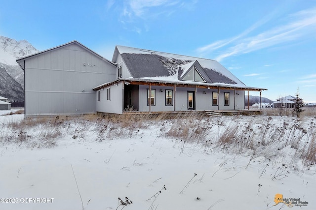 snow covered rear of property with a porch