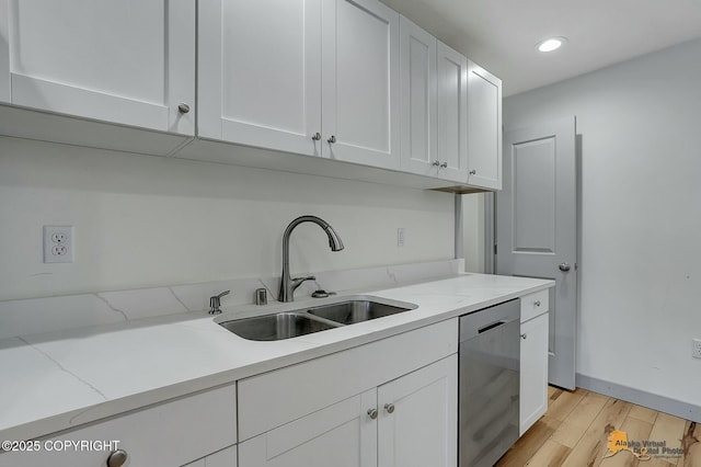 kitchen featuring sink, stainless steel dishwasher, white cabinets, and light stone countertops