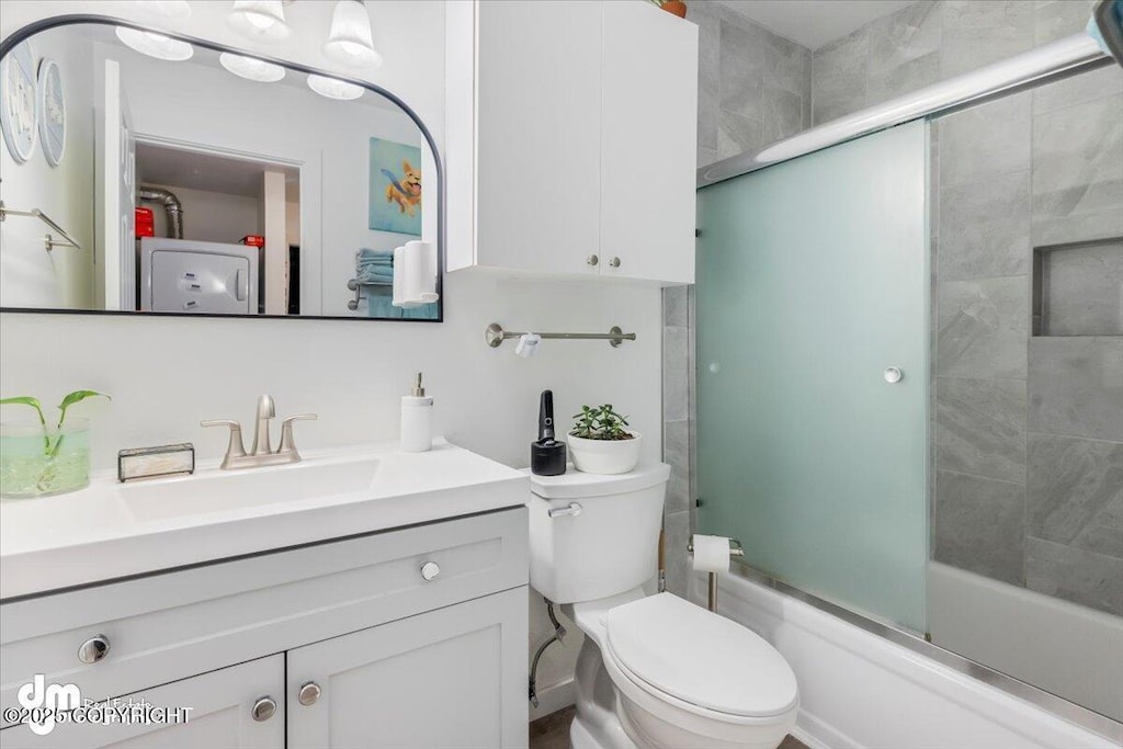 full bathroom with enclosed tub / shower combo, vanity, and toilet