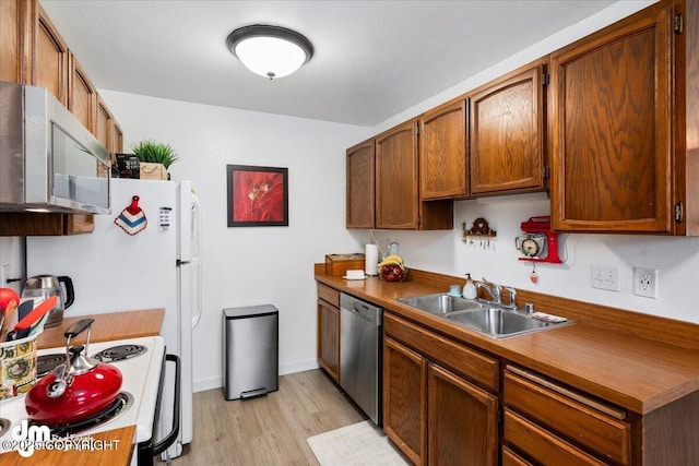 kitchen with sink, light wood-type flooring, and appliances with stainless steel finishes