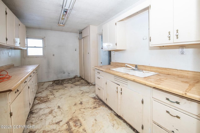 kitchen featuring white cabinetry and sink