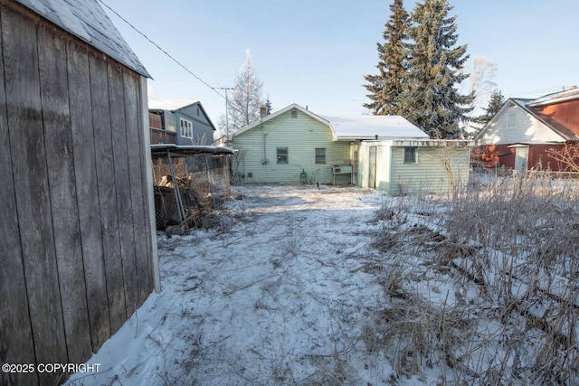 view of snow covered back of property