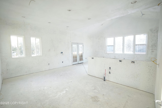 unfurnished room with lofted ceiling and french doors