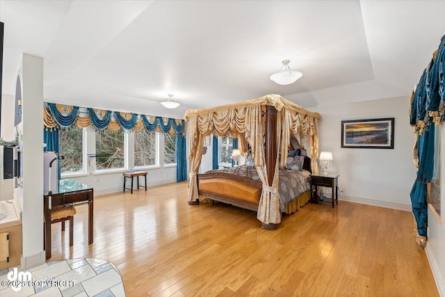 bedroom with hardwood / wood-style flooring and multiple windows