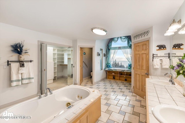 bathroom with vanity, toilet, and a bathing tub