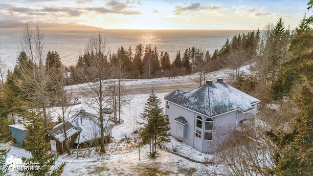 snowy aerial view featuring a water view