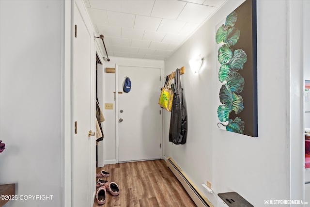 hallway featuring a baseboard heating unit and light wood-type flooring