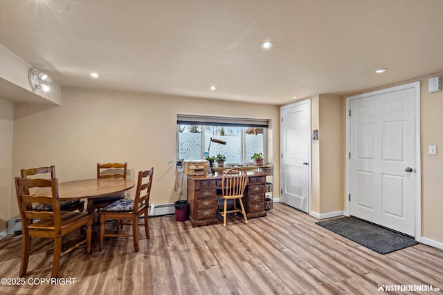 dining room featuring a baseboard heating unit and light wood-type flooring