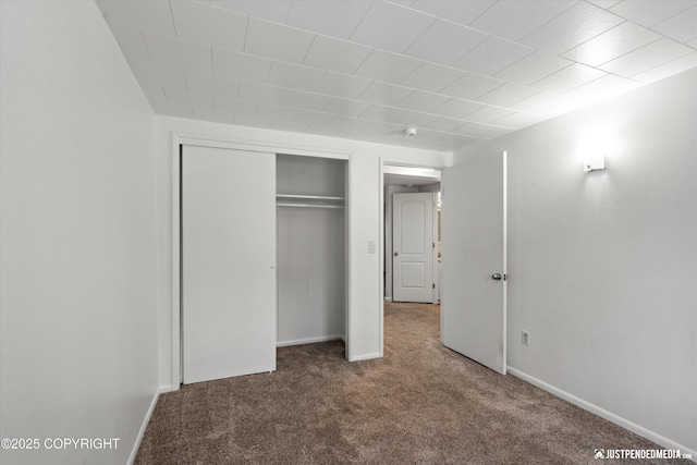 unfurnished bedroom featuring carpet flooring and a closet