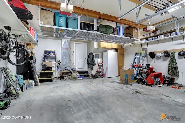 garage featuring white refrigerator and a garage door opener