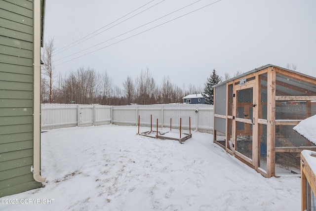 yard covered in snow with an outbuilding