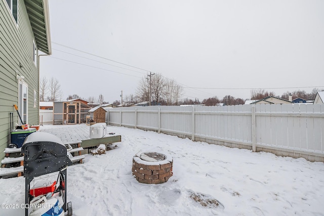 yard layered in snow featuring a fire pit