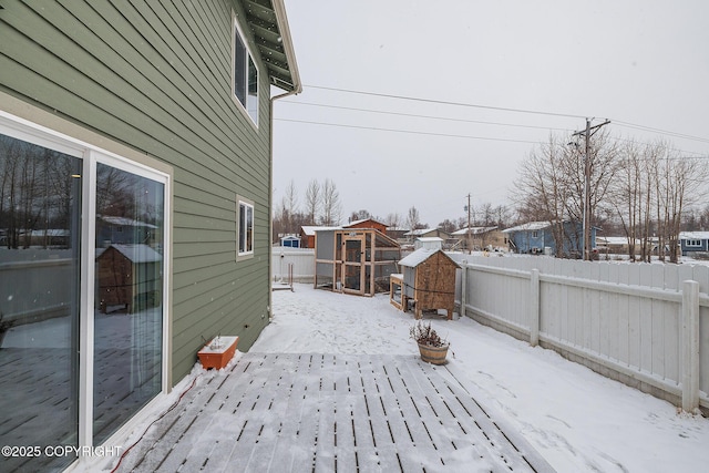 snow covered deck featuring an outdoor structure