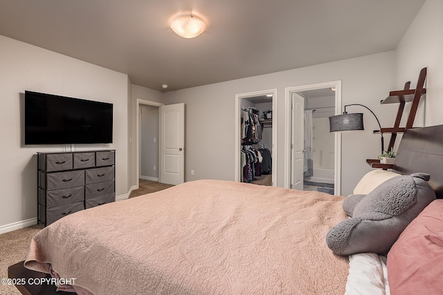 bedroom featuring a walk in closet, ensuite bath, carpet floors, and a closet