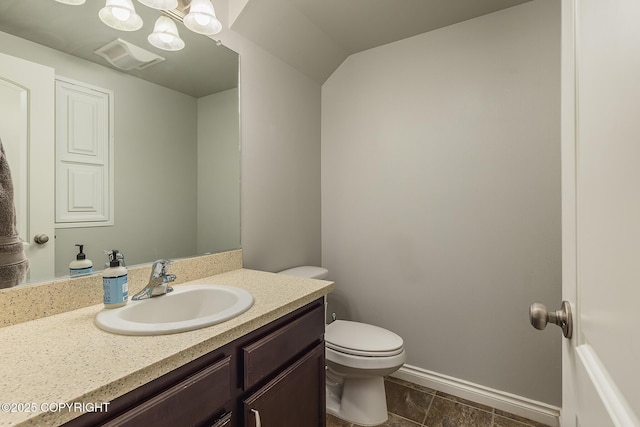 bathroom with vanity, lofted ceiling, an inviting chandelier, and toilet