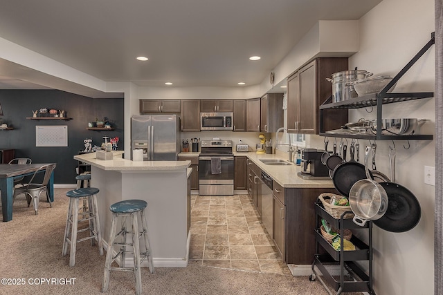 kitchen featuring stainless steel appliances, a kitchen island, sink, and dark brown cabinets