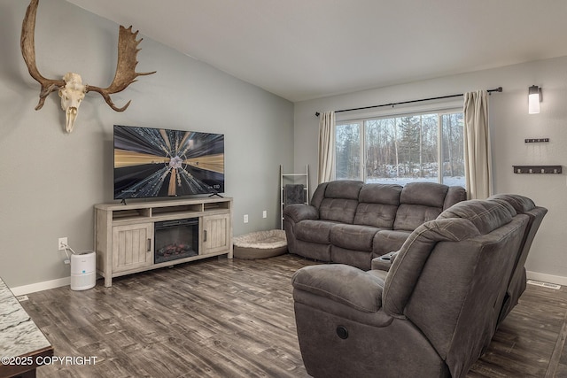 living room featuring vaulted ceiling and dark hardwood / wood-style floors