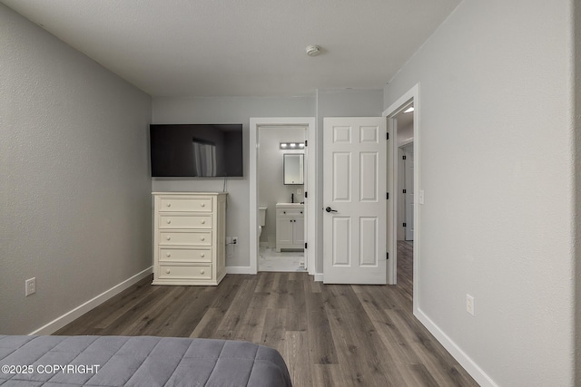 unfurnished bedroom featuring dark wood-type flooring and connected bathroom