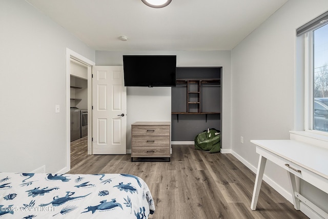 bedroom featuring wood-type flooring, washer / clothes dryer, and a closet