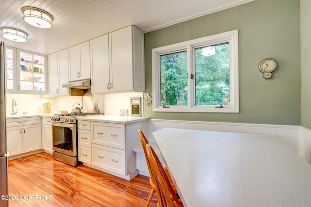 kitchen featuring gas stove, white cabinets, and light wood-type flooring