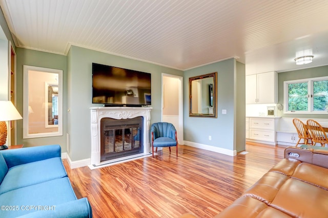 living room with ornamental molding and light hardwood / wood-style flooring