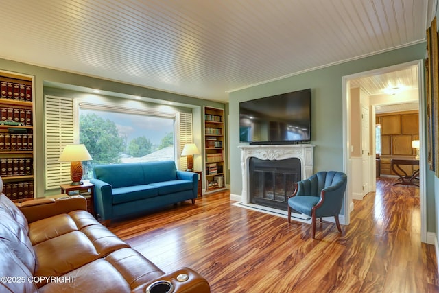 living room featuring crown molding, hardwood / wood-style flooring, and built in features