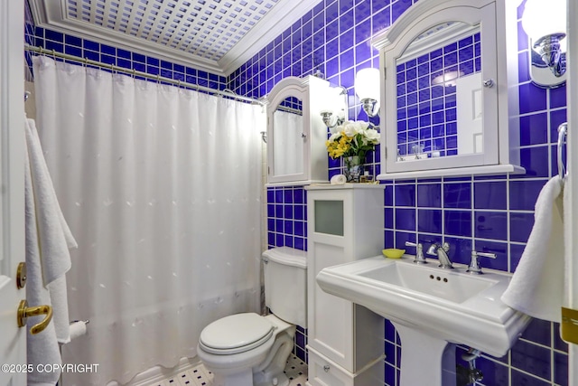 full bathroom with sink, tile walls, shower / bath combination with curtain, ornamental molding, and toilet