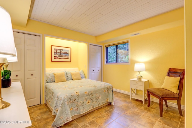 bedroom featuring two closets and wood ceiling