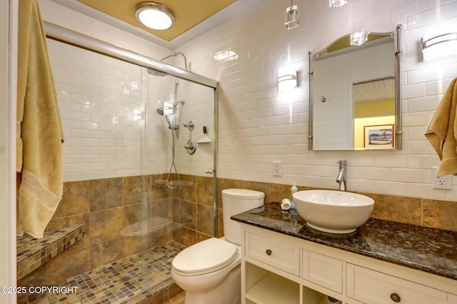 bathroom with toilet, tile walls, and a shower with shower door