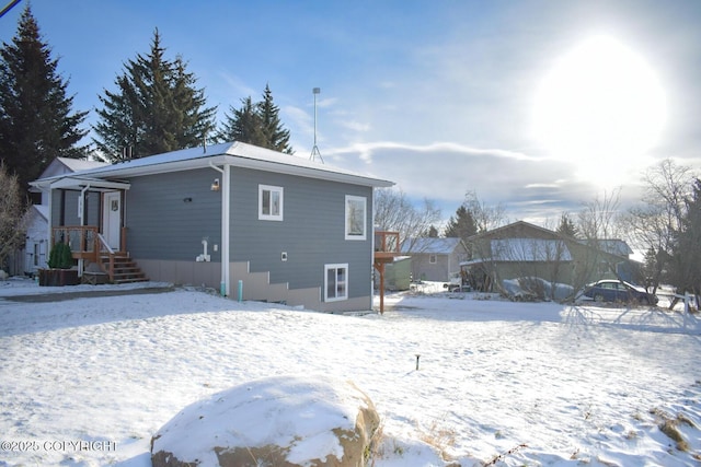 view of snow covered back of property