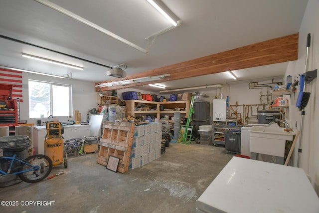 garage featuring sink, a garage door opener, a workshop area, and tankless water heater