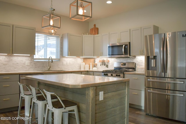 kitchen with appliances with stainless steel finishes, pendant lighting, sink, decorative backsplash, and a center island