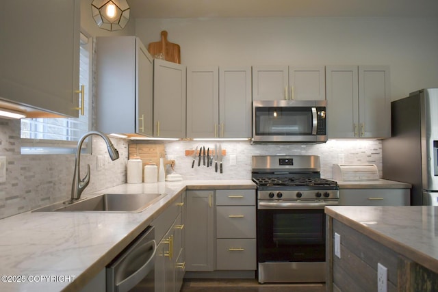 kitchen featuring sink, decorative backsplash, stainless steel appliances, and light stone countertops